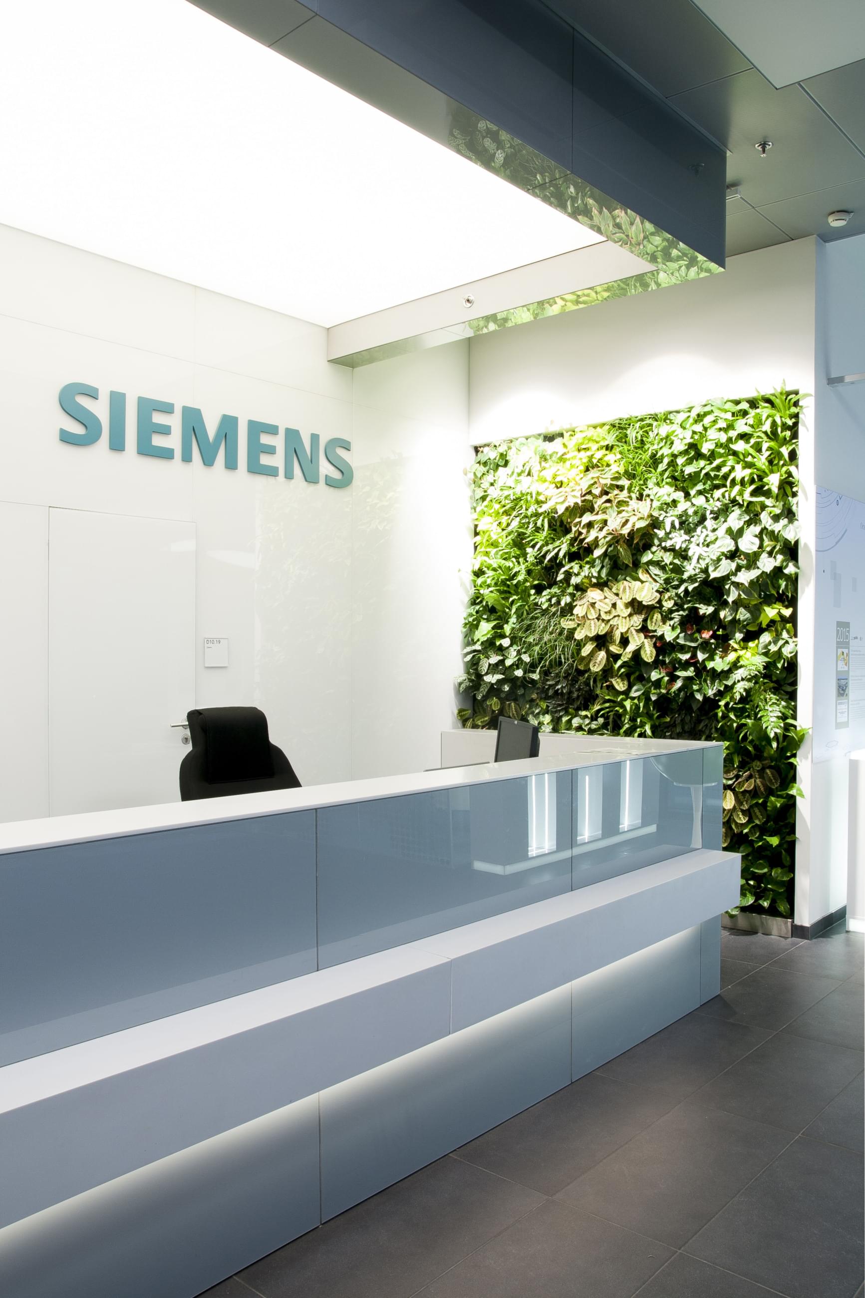 Recepce Siemens je provedena v moderním duchu a ostrých křivkách, kde je jedna stěna pokrytá živými rostlinami.