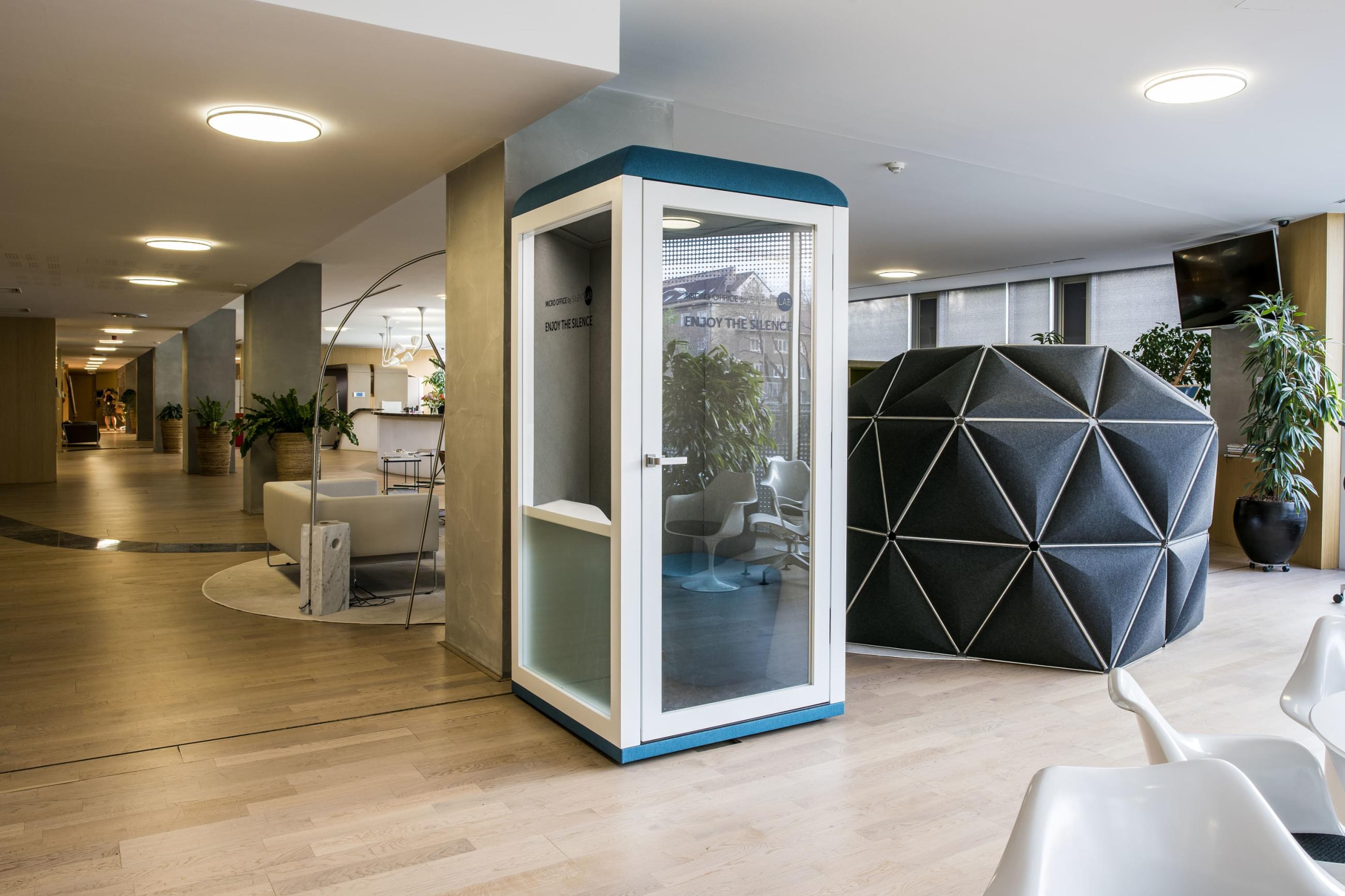 Uzavřený microoffice  v podobě prosklené telefonní budky uprostřed kancelářských prostor.
