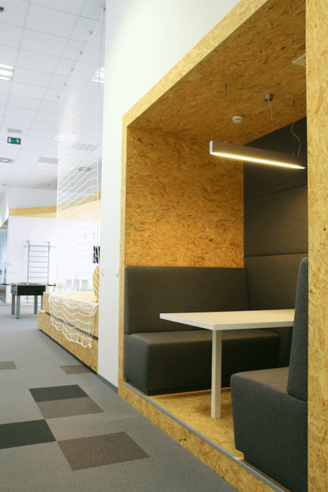 Relaxační zóna se soft seatingovými sedačkami oddělená od open space prostoru. 