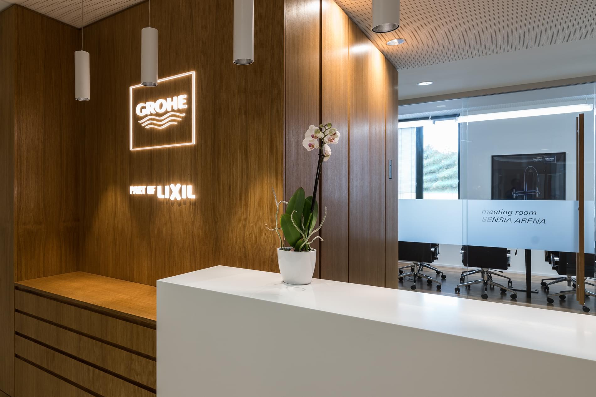 Detail na recepční pult a LED svítící logo firmy GROHE